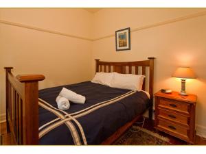 a bedroom with a bed with two pillows on it at Fairholme Apartment in Warrnambool