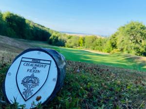 a sign in the grass next to a golf course at Vexin Studio in Chaumont-en-Vexin