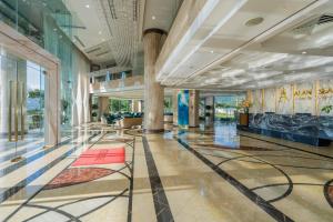 a lobby of a building with glass walls at Alan Sea Hotel Danang in Da Nang