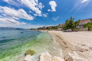 a beach with rocks and the water and buildings at Studio Slatine 13298e in Trogir