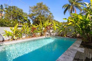 a swimming pool in the middle of a yard with trees at Styled 3 BR Tropical Family Home w Pool at Coolum in Coolum Beach