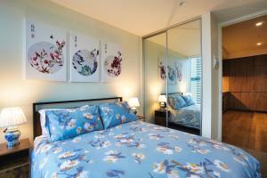 a bedroom with a blue bed and a mirror at Luxury City Zen Apartment Rundle Mall with Rooftop Spa, Gym, BBQ in Adelaide