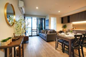 cocina y sala de estar con mesa y sofá en Luxury City Zen Apartment Rundle Mall with Rooftop Spa, Gym, BBQ, en Adelaida