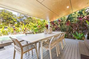 a white table and chairs on a wooden deck at Styled 3 BR Tropical Family Home w Pool at Coolum in Coolum Beach