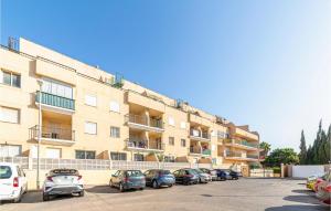 a parking lot with cars parked in front of a building at 1 Bedroom Gorgeous Apartment In Roquetas De Mar in Roquetas de Mar