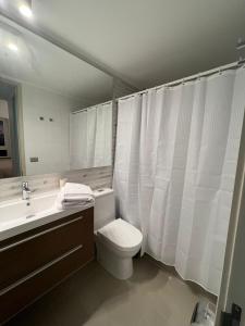 a bathroom with a toilet and a sink and a mirror at Perfecto departamento 1dorm/1baño in Concepción