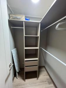 a closet with shelves and a chair in a room at Perfecto departamento 1dorm/1baño in Concepción