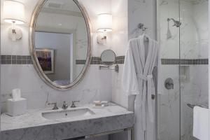 a white bathroom with a sink and a mirror at The Lenox in Boston