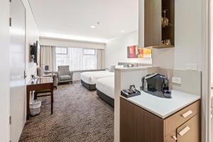 a hotel room with a bed and a kitchen and a bedroom at The Colmslie Hotel in Brisbane
