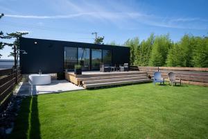 a backyard with a black house with a lawn at Trailer room - Vacation STAY 06457v in Makinohara