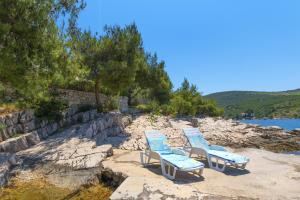 three lounge chairs sitting on a beach near the water at Apartments by the sea Cove Pribinja, Hvar - 15083 in Hvar