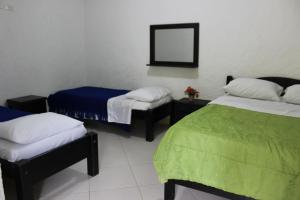 Zimmer mit 2 Betten und einem Spiegel in der Unterkunft Centro Vacacional Paraiso Termal in Tibirita