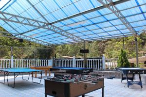 a glass roofed patio with ping pong tables at Centro Vacacional Paraiso Termal in Tibirita