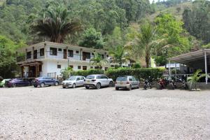 eine Gruppe von Autos, die vor einem Gebäude geparkt sind in der Unterkunft Centro Vacacional Paraiso Termal in Tibirita