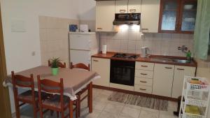 a kitchen with a table and a sink and a stove at Apartments by the sea Slatine, Ciovo - 4844 in Slatine