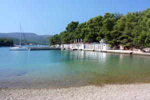 a body of water with a white building and a boat at Apartments with WiFi Stari Grad, Hvar - 15464 in Stari Grad