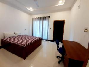 a hotel room with a bed and a desk and a desk at Hotel krish in Kalkudah