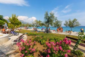 park z różowymi kwiatami i ludźmi na plaży w obiekcie Family friendly house with a swimming pool Kastel Stari, Kastela - 15531 w mieście Kaštela