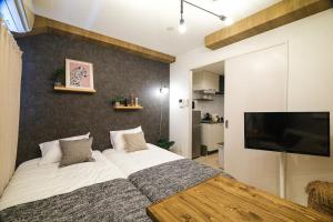 a bedroom with a large bed and a flat screen tv at La Lumiere Oroku in Akamine