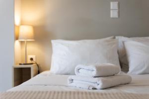 una pila de toallas sentadas encima de una cama en Mood Athens Luxury Apartments and Suites en Athens