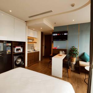 IVORY Apartment Apec Phu Yen with POOL Access في توي هوا: غرفة بسرير ومطبخ مع طاولة