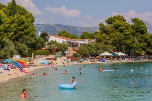 a group of people in the water at a beach at Apartments with parking space Kastel Stafilic, Kastela - 16086 in Kaštela