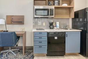 a kitchen with a sink and a microwave at Candlewood Suites Longview by IHG in Longview +20 photos