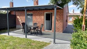 - un pavillon avec une table et des chaises sur la terrasse dans l'établissement Ferienhaus am Binnenhafen, à Emden