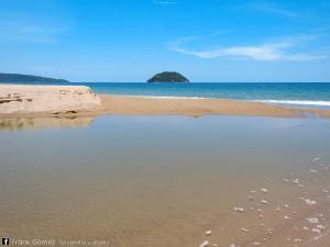 a beach with footprints in the sand and the ocean at Bungalows Maria Teresa in Rincon de Guayabitos