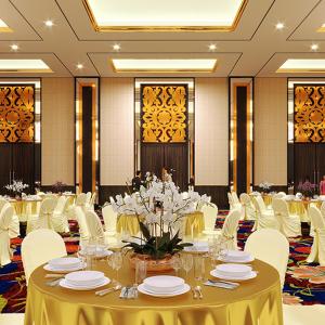 um salão de banquetes com mesas brancas e cadeiras brancas em ASTON Tanjung Pinang Hotel & Conference Center em Tanjung Pinang