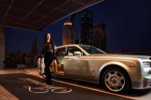 a woman is standing in front of a car at Fairmont Dubai in Dubai