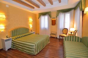 a hotel room with a bed and two chairs at Hotel Da Bruno in Venice