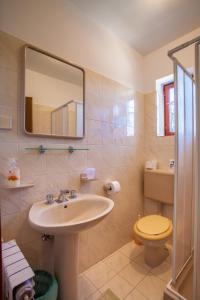 a bathroom with a sink and a toilet and a mirror at Rooms with a parking space Cres - 2512 in Cres