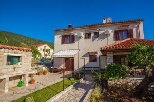 a large white house with a patio in front of it at Rooms with a parking space Cres - 2512 in Cres +14 photos