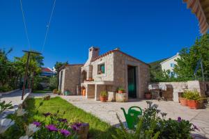 a stone house with a garden in front of it at Rooms with a parking space Cres - 2512 in Cres