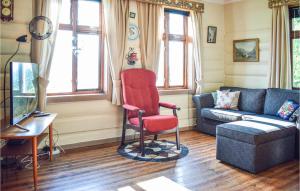 un soggiorno con sedia rossa e divano di Stunning Home In Brekke With Kitchen a Brekke