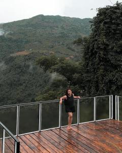 a woman standing on a deck with a view of a mountain at Captain’s Villa and Campsite in Cebu City