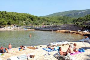 a group of people sitting on the beach at Apartments with parking space Jelsa, Hvar - 4040 in Jelsa