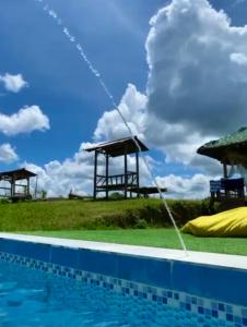 uma piscina com dois gazebos ao lado em Captain’s Villa and Campsite em Cebu