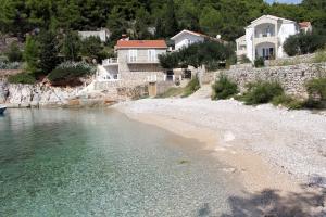 a beach with houses on a hill next to the water at Seaside secluded apartments Cove Jedra, Hvar - 2583 in Gdinj