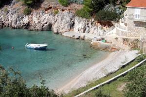 a boat in the water next to a beach at Seaside secluded apartments Cove Jedra, Hvar - 2583 in Gdinj