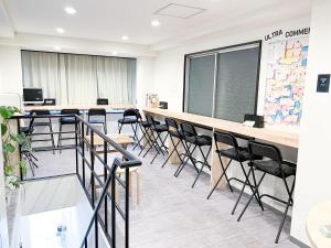 uma sala de aula com mesas e cadeiras e um quadro-negro em Osaka Nipponbashi EVISU HOSTEL em Osaka