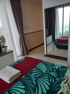 a bedroom with a bed and a large mirror at Sunset View 969 PD Waterfront in Port Dickson