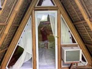 una persona que toma una foto de una ventana en una casa del árbol en Captain’s Villa and Campsite, en Cebú