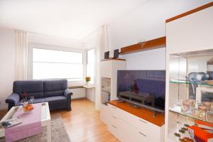 ein Wohnzimmer mit einem Sofa und einem TV in der Unterkunft Hanseat I Whg 72 in Grömitz