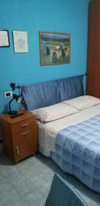 Un dormitorio con una cama y una mesa con una lámpara. en La Finestra Sul Cortile, en Pomezia