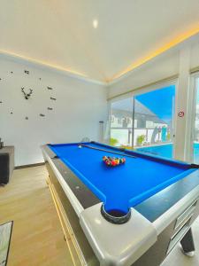 a pool table in a living room with a clock at Nayjoe Poolvilla Cha-am in Cha Am