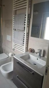 ein Badezimmer mit einem Waschbecken, einem WC und einem Spiegel in der Unterkunft eli 's home in Vasto