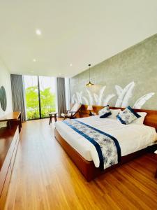 ein Schlafzimmer mit einem großen Bett und einem großen Fenster in der Unterkunft VEDANA VILLAS RESORT NINH BÌNH in Phủ Nho Quan