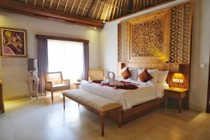 a bedroom with a large bed in a room at Puri Andong Villa in Ubud